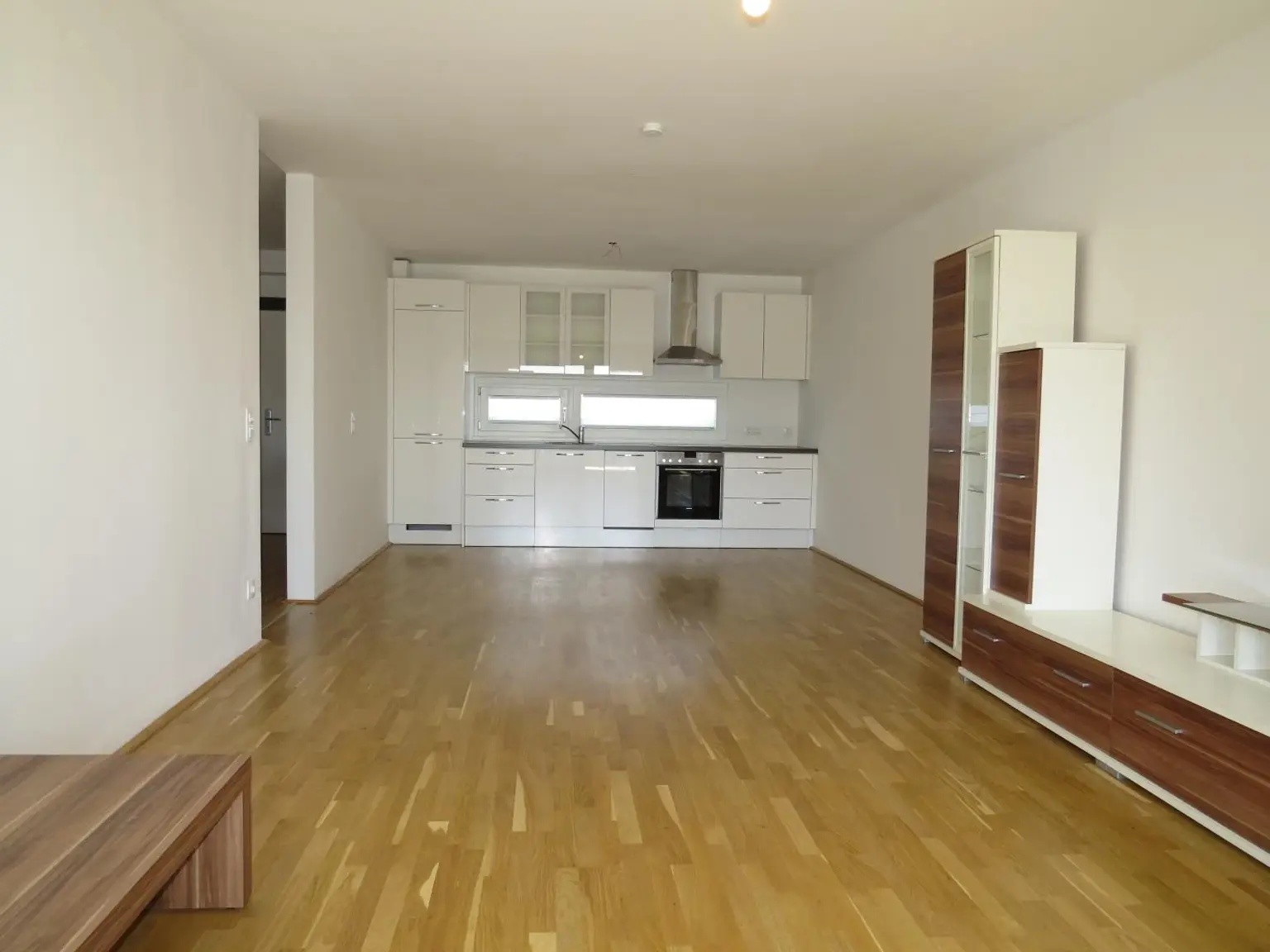 großes Wohnzimmer mit moderner Küche