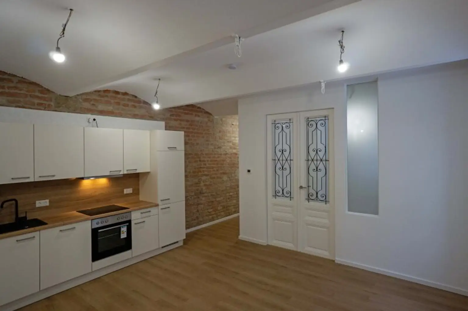 Wohnküche Richtung Wohnzimmer mit Doppelflügeltür mit satiniertem Glas und schmiedeeisernem Gitter