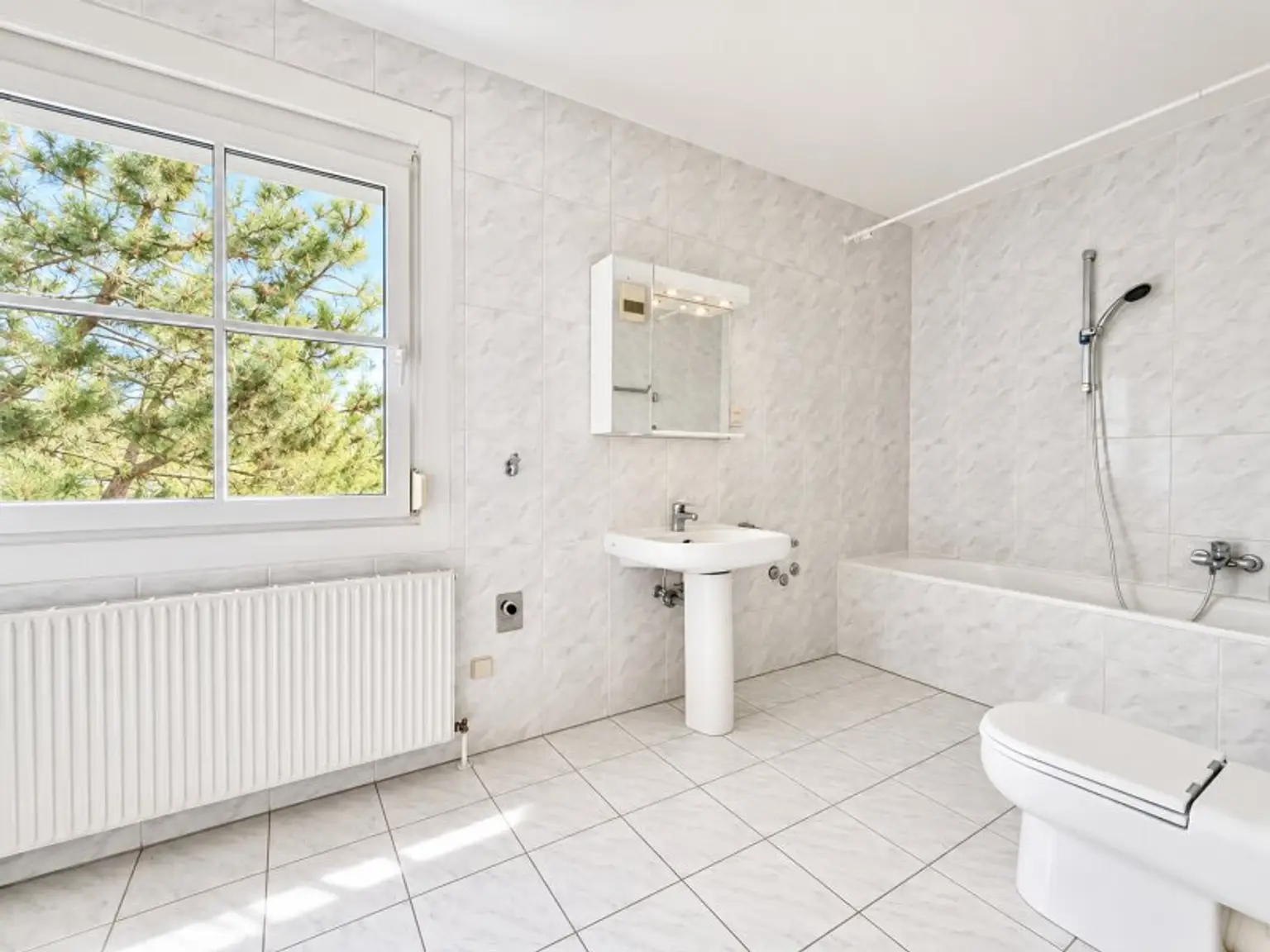Badezimmer mit Wanne, Waschtisch, WC und Waschmaschinen-Anschluss
