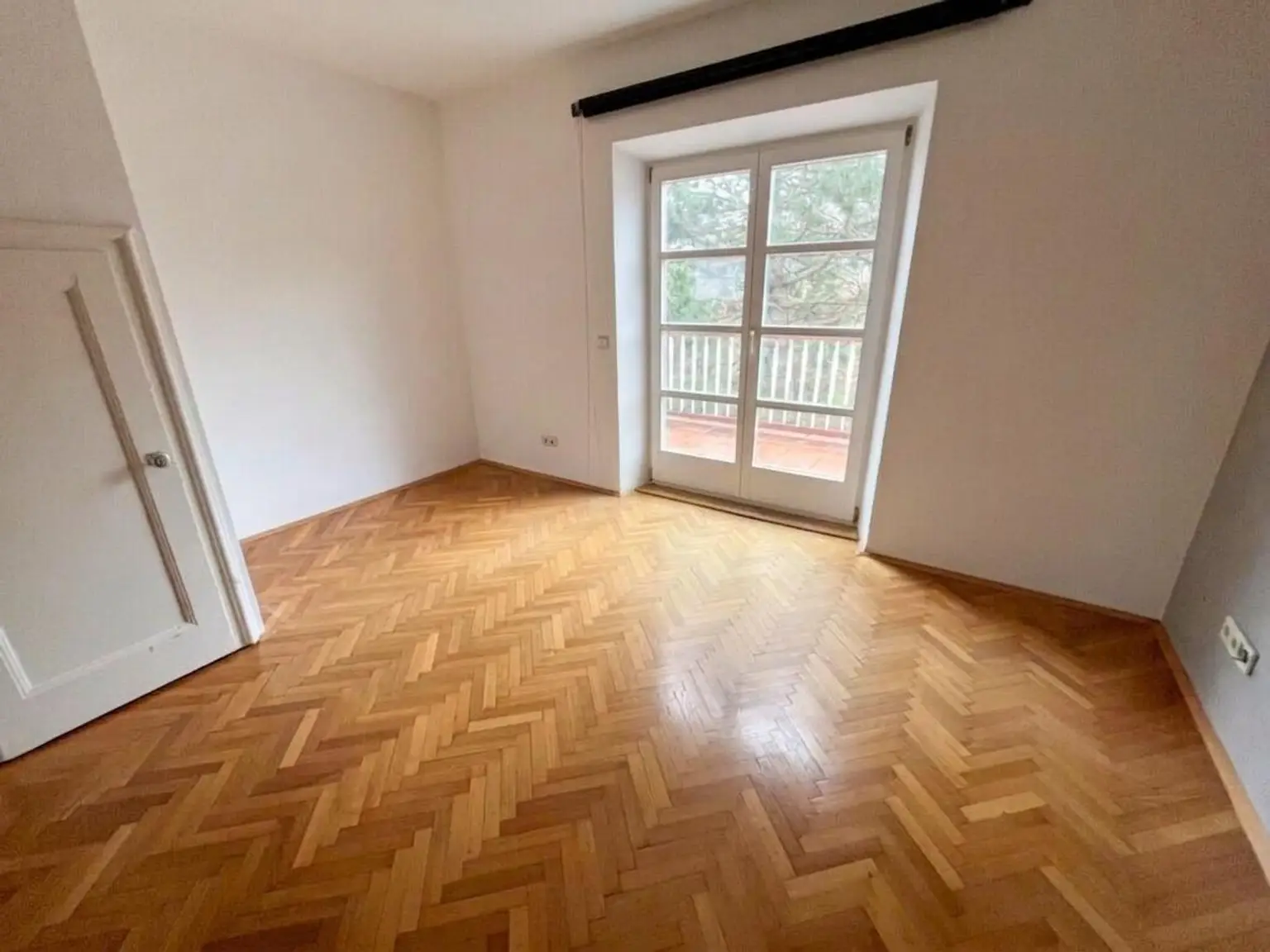 Zimmer im Obergeschoss mit Zugang zum Balkon