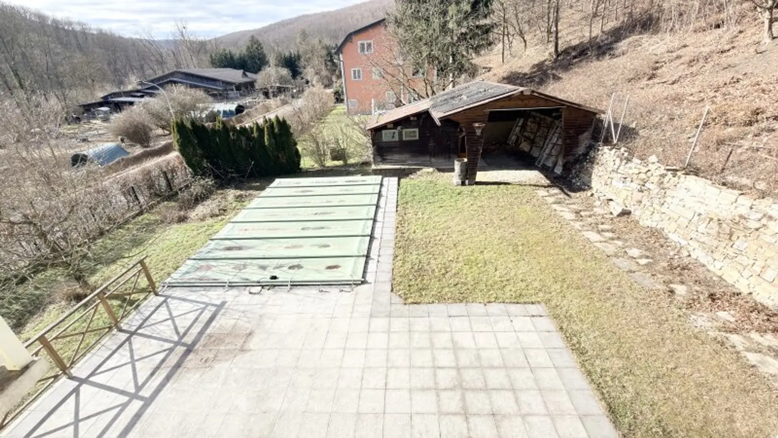 Blick vom 1. Stock auf Terrasse und abgedeckten Pool