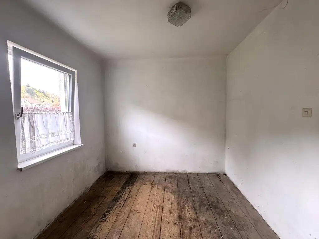 Sanierungsbedürftiges Mehrfamilienhaus mit großem Grundstück und hoher Bebauungsdichte