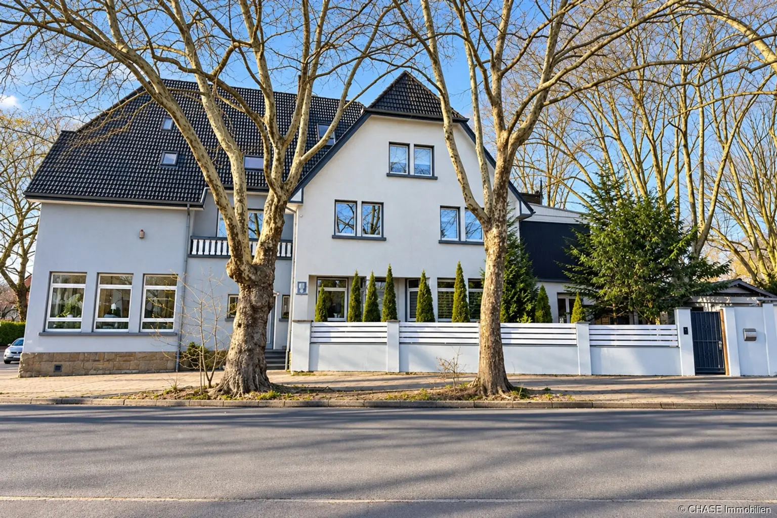 helles_stadthaus_zwischen_kahlen_bäumen