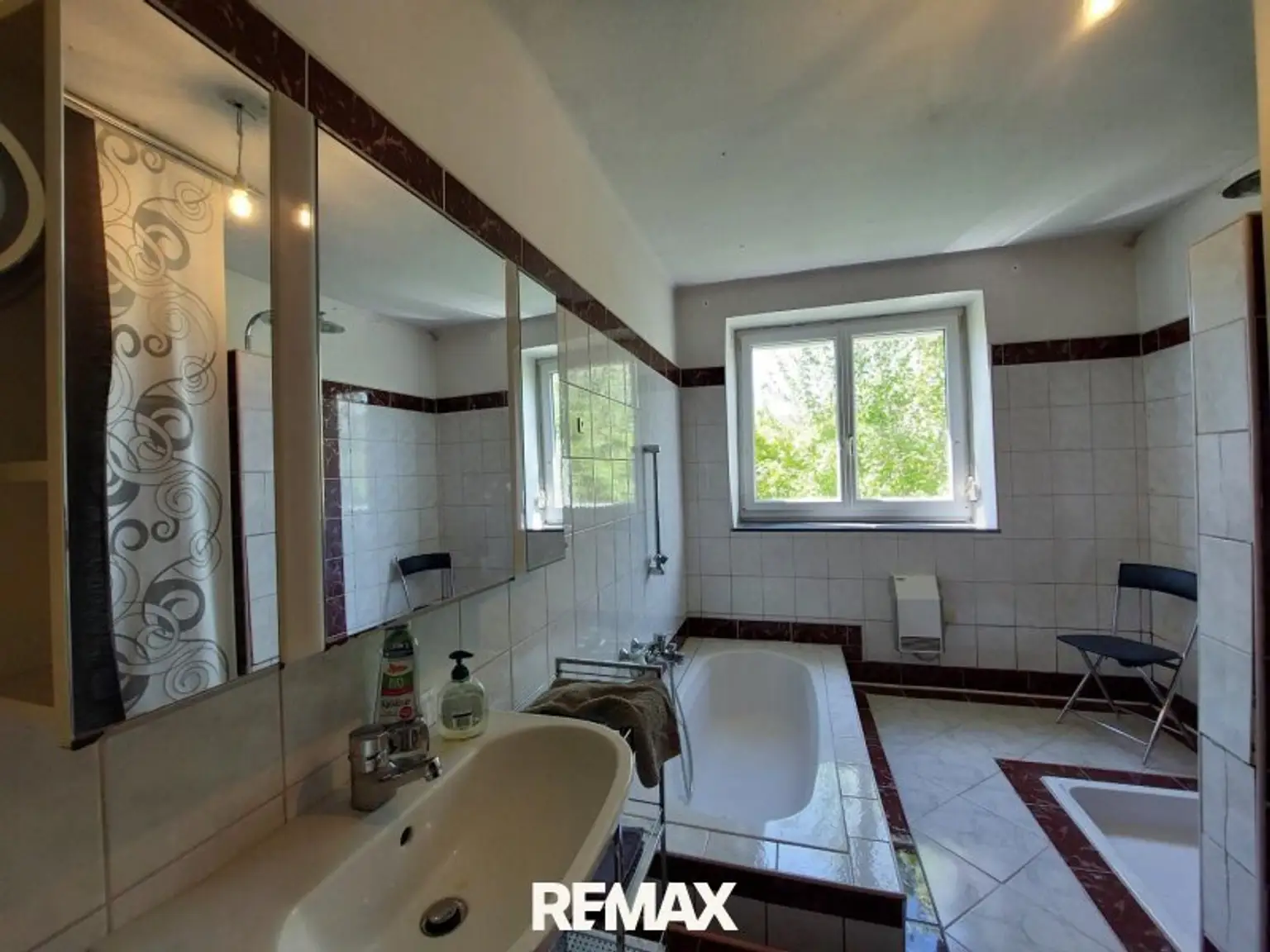 Badezimmer mit versenkter Badewanne und Dusche