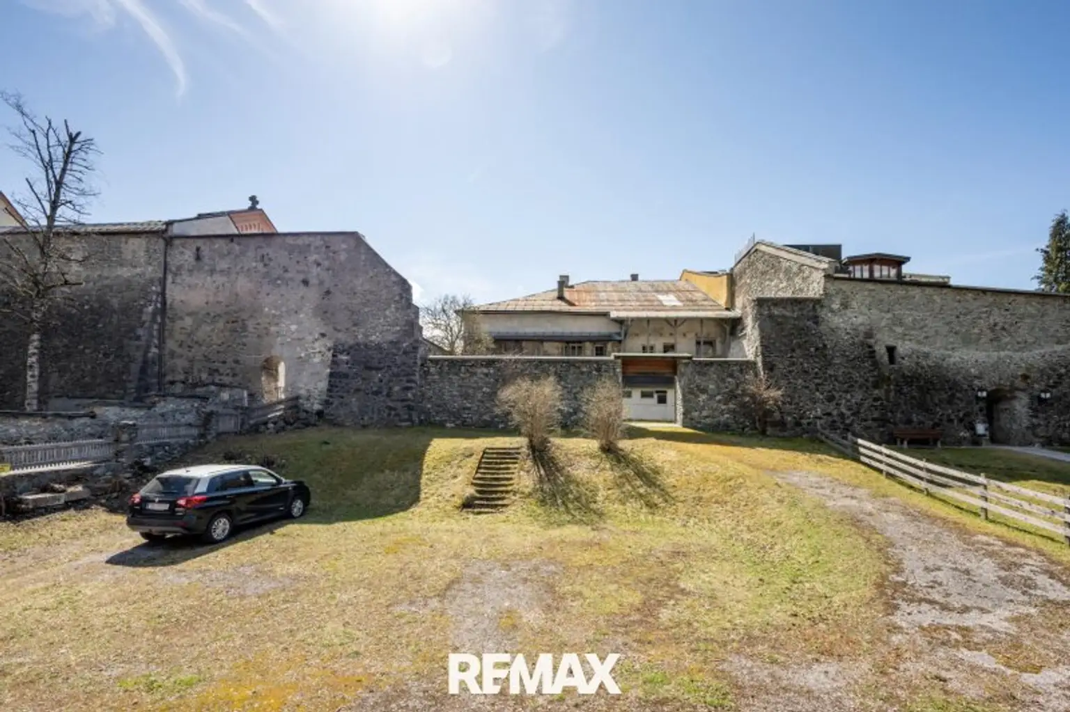Grund mit Stadtmauer und Haus dahinter
