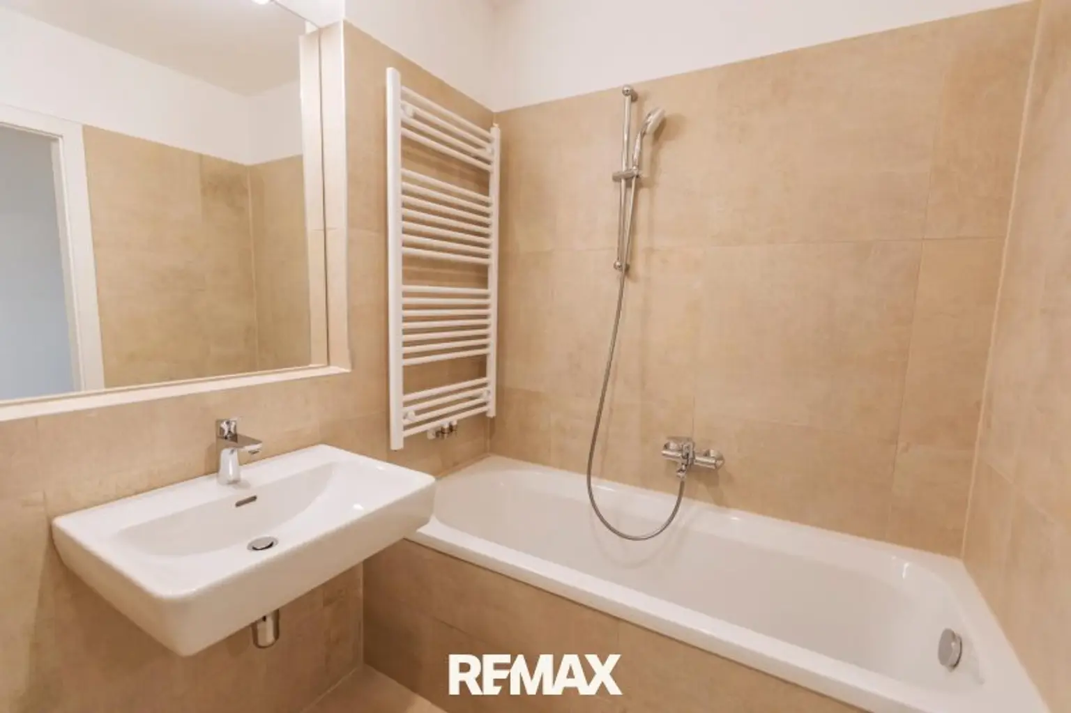 geschmackvolles Badezimmer mit Badewanne und Sprossenheizkörper