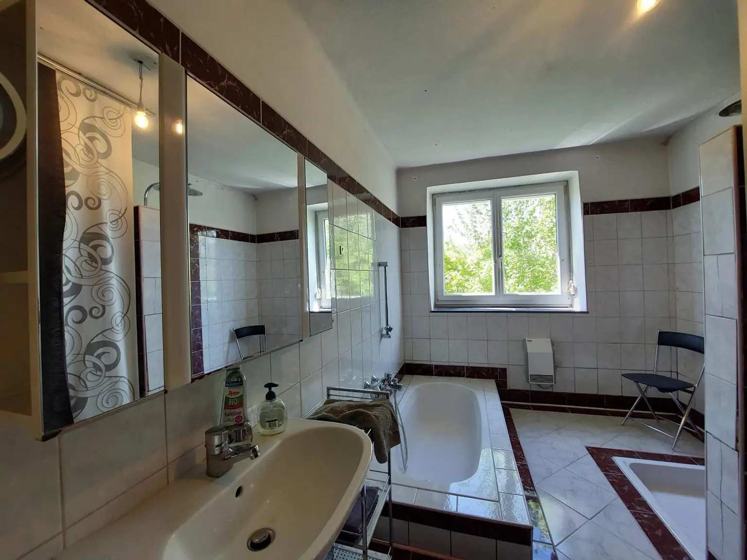 Badezimmer mit versenkter Badewanne und Dusche