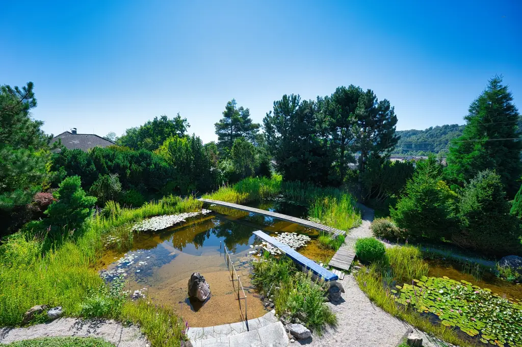 Exklusivität und Privatsphäre pur auf 2.610 m2 Grundfläche! Von der Terrasse in den Schwimmteich.