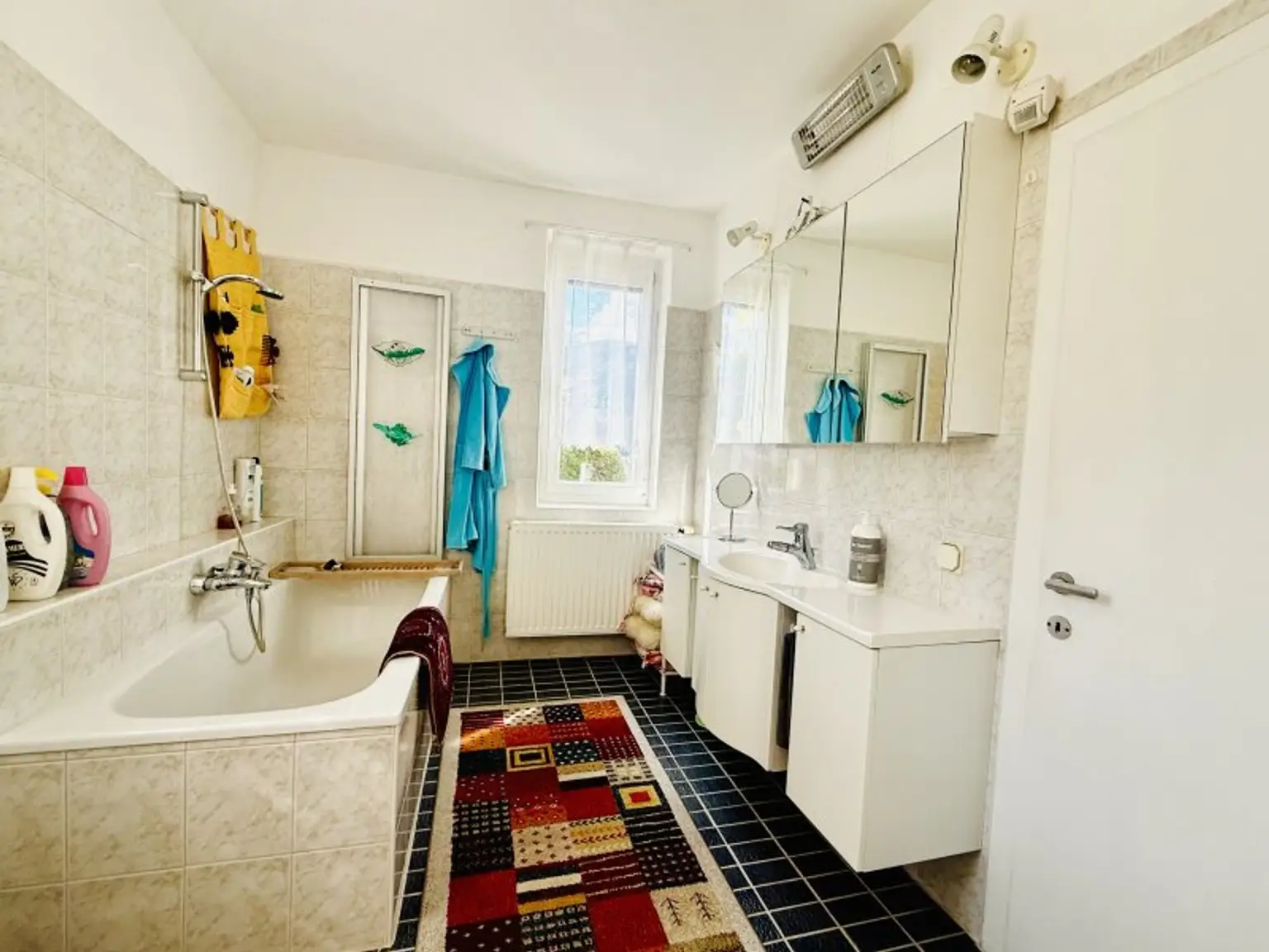 Badezimmer mit Wanne, Dusche und Fenster