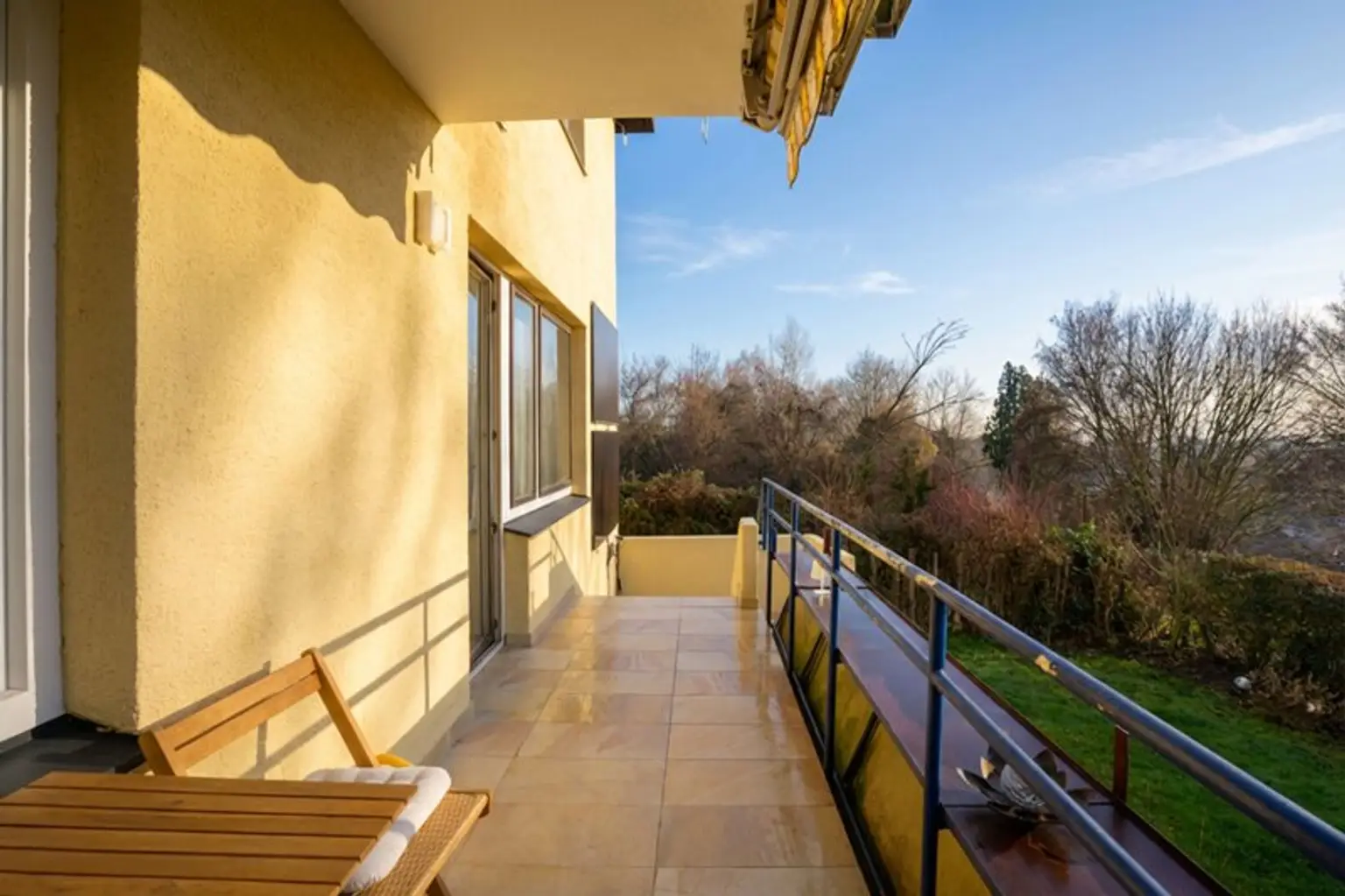 Balkon mit Markise und Stiegen hinunter in den Garten