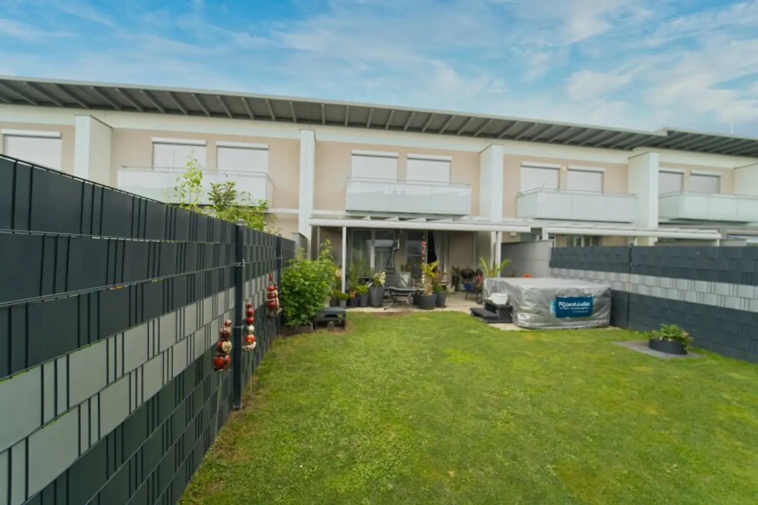 Hausansicht von Garten mit Blick auf Terrasse und Balkon