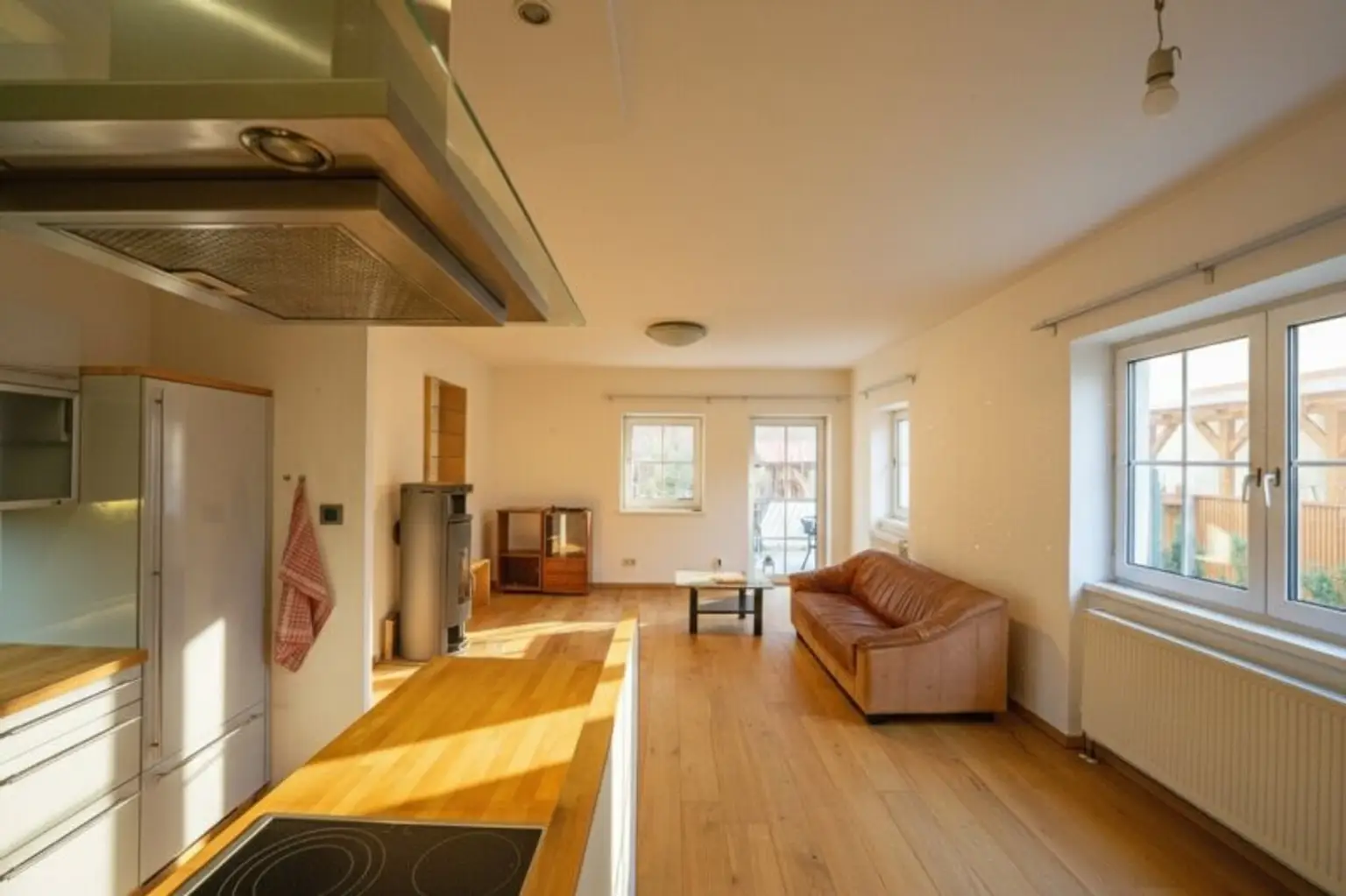 Wohnzimmer mit offener Küche, Schwedenofen und Ausgang auf die Terrasse