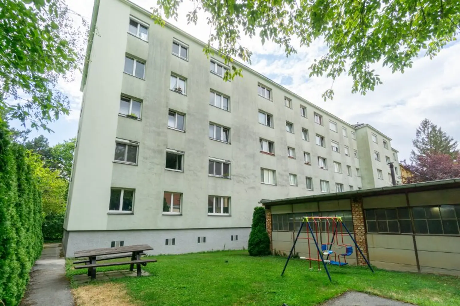 Aussenansicht Wohnhaus mit Kinderspielplatz