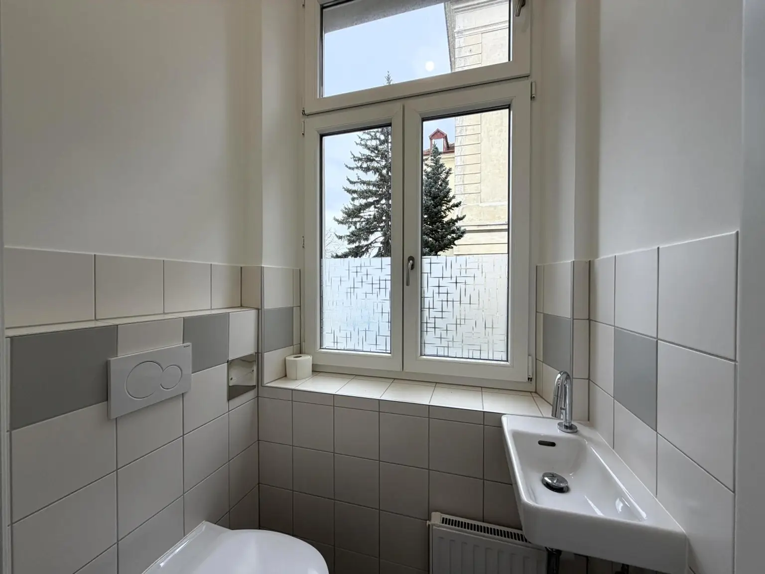 Toilette mit Handwaschbecken und Fenster