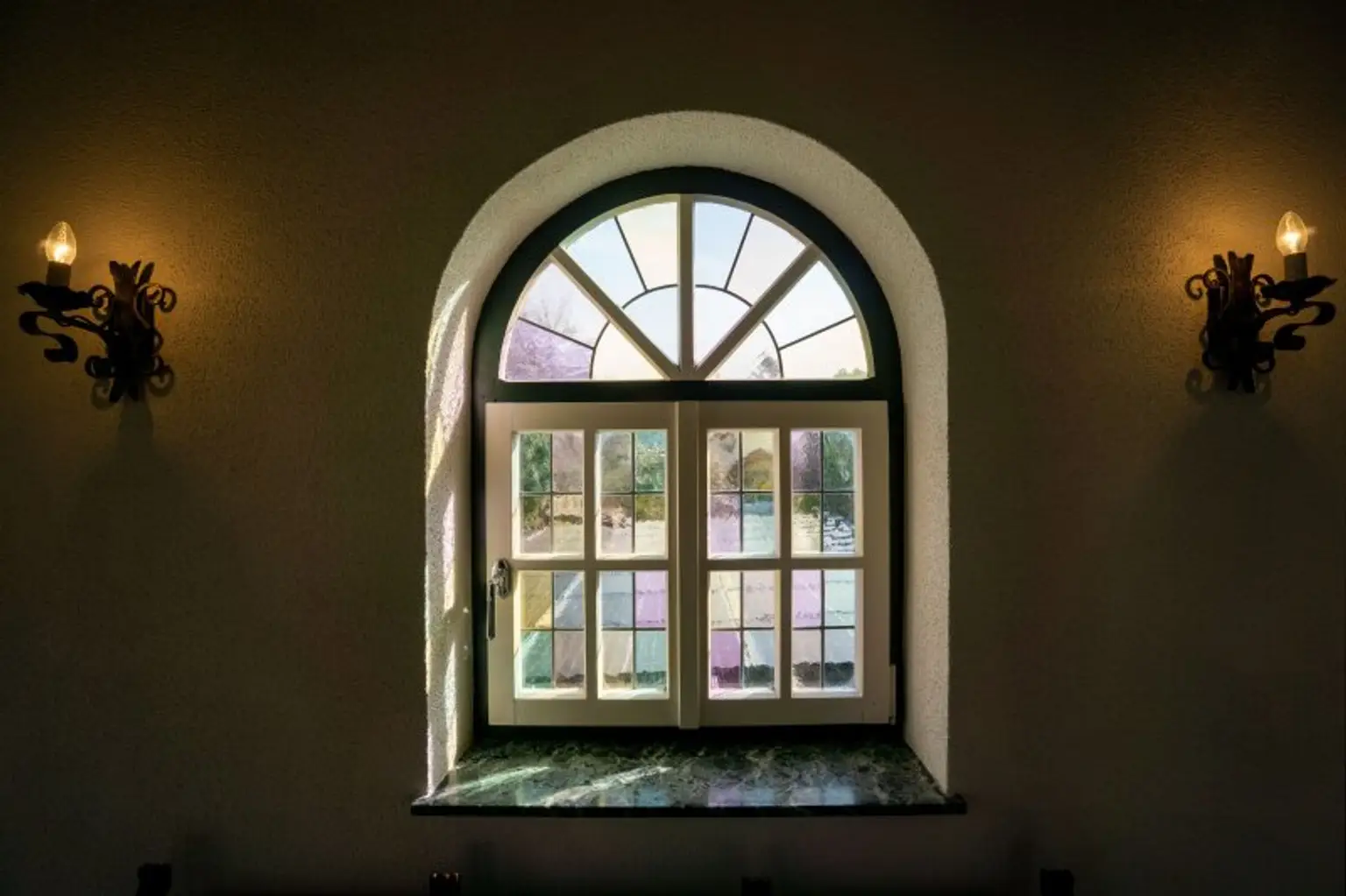 Bogenfenster aus Holz mit Sprossenteilung und buntem Strukturglas