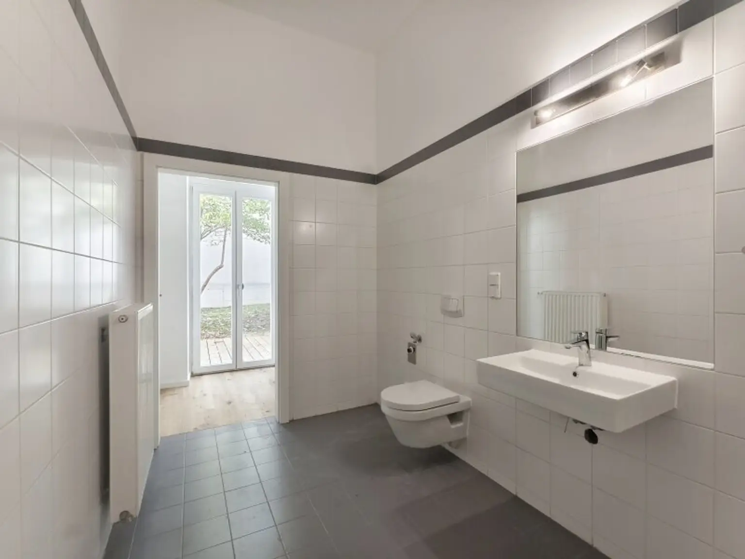 Badezimmer mit Blick in den Vorraum und Garten