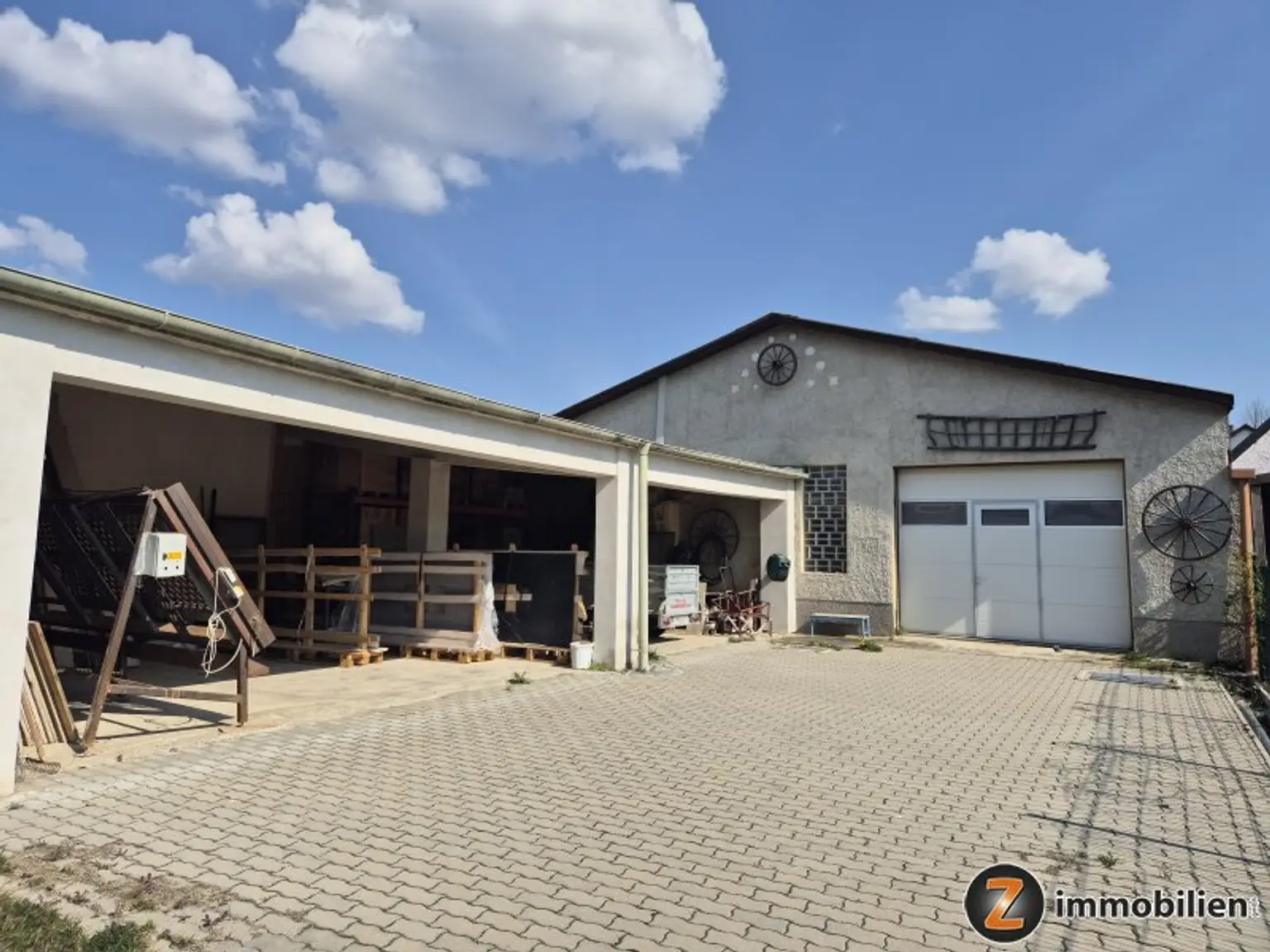 Blick vom Garten zum offenen Lager und der Halle