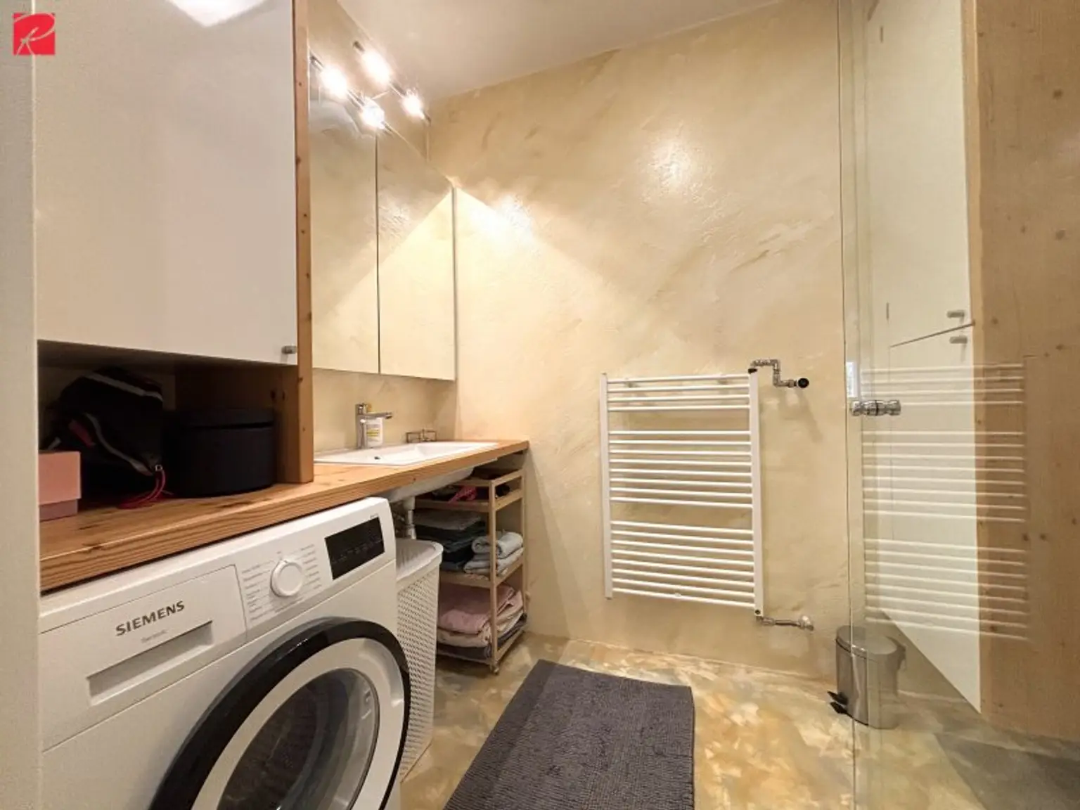 Badezimmer mit Tischlermöbeln und Handtuchtrockner