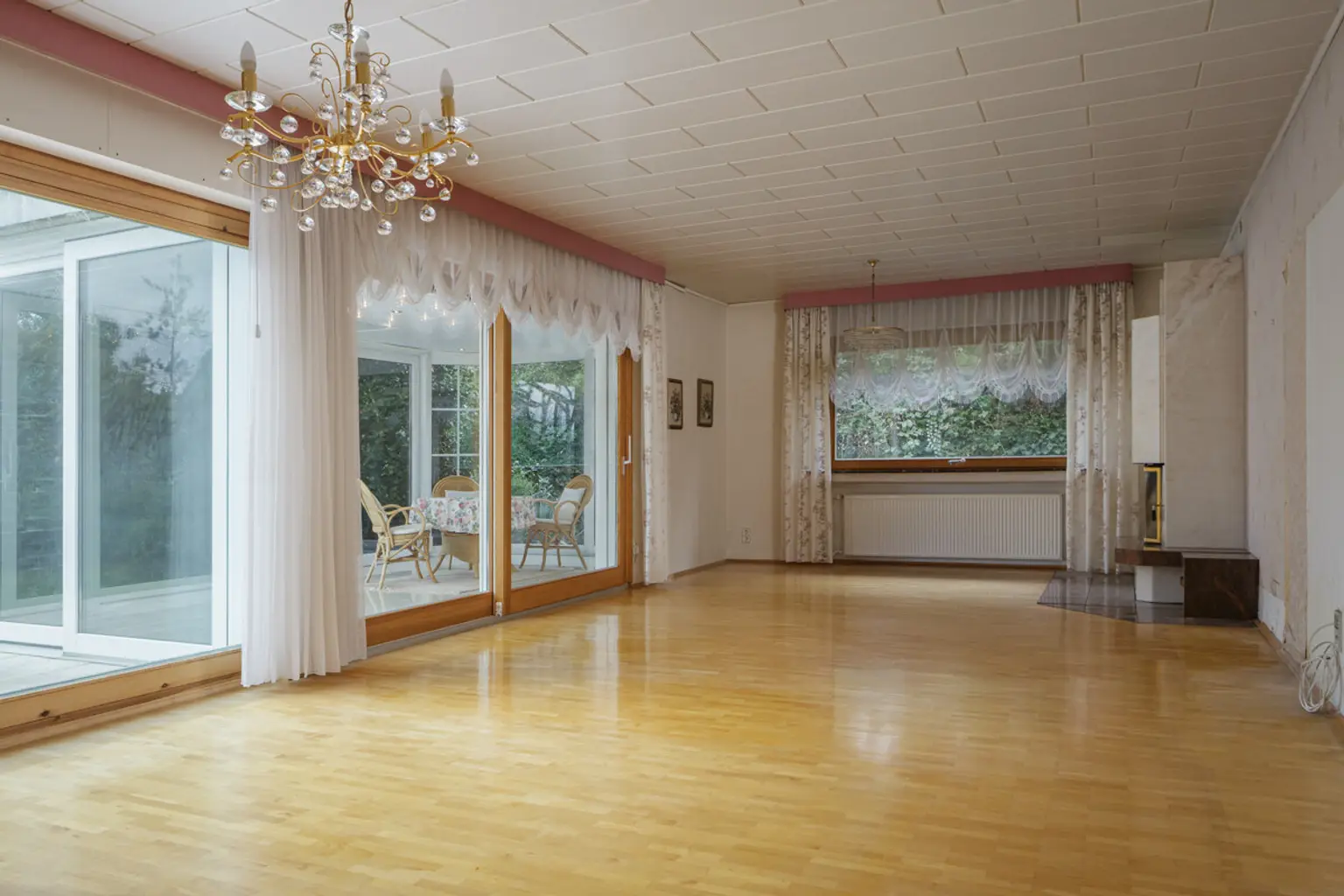 Das Wohnzimmer mit Kamin und dem Wintergarten