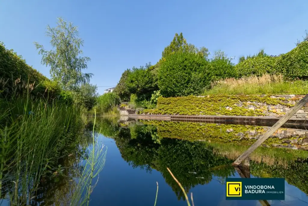 Stadt trifft Land: Exklusive Villa mit Gartenidylle und Schwimmbiotop in Ruhelage.