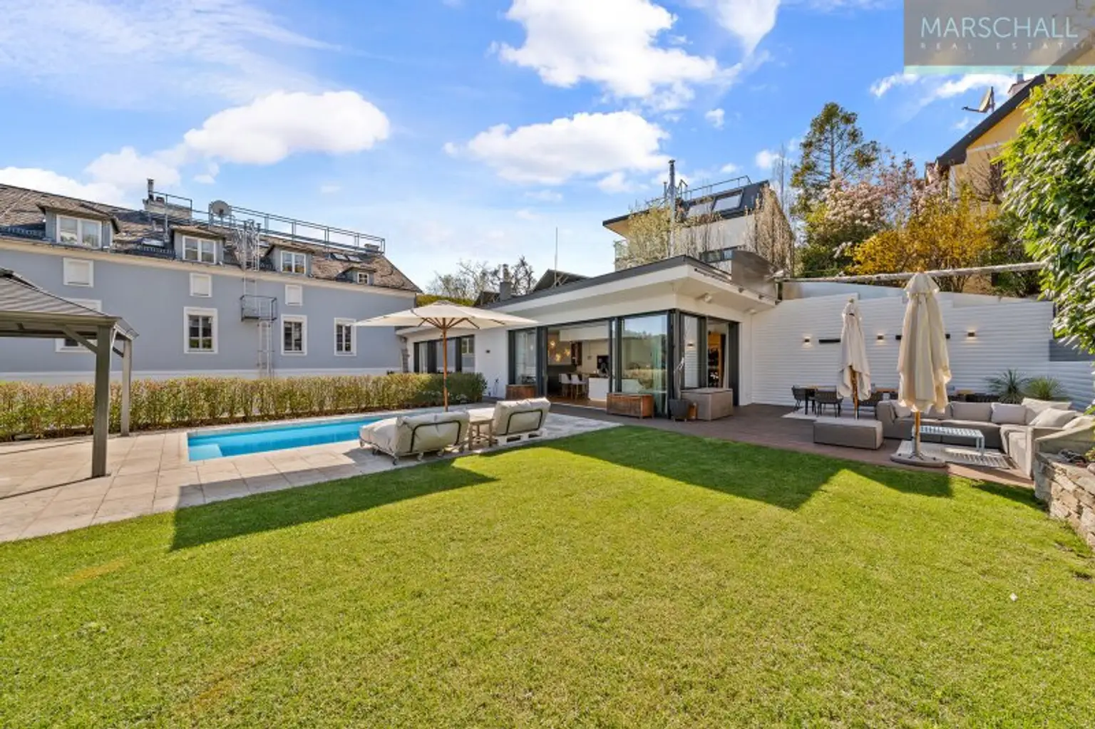 Blick über den Garten auf den historischen Altbau mit modernem Zubau