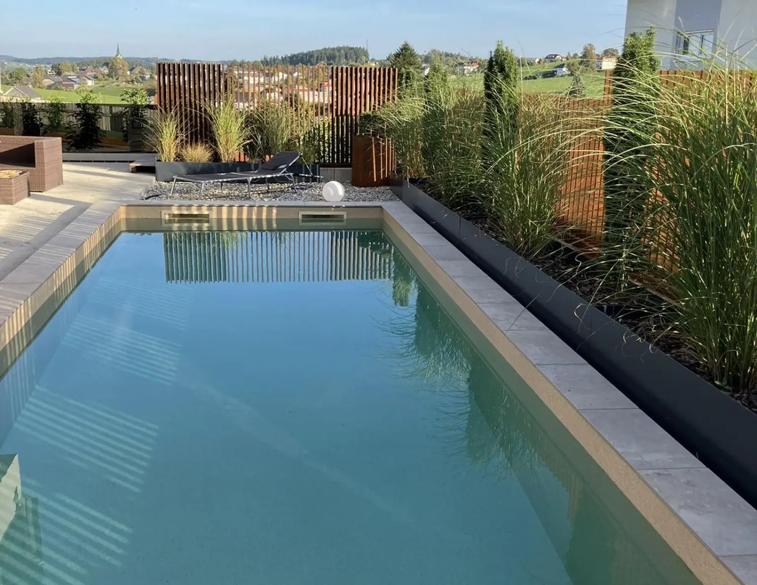 Zuhause ankommen: Traumhaus mit Salzwasserpool und moderner Gartengestaltung.