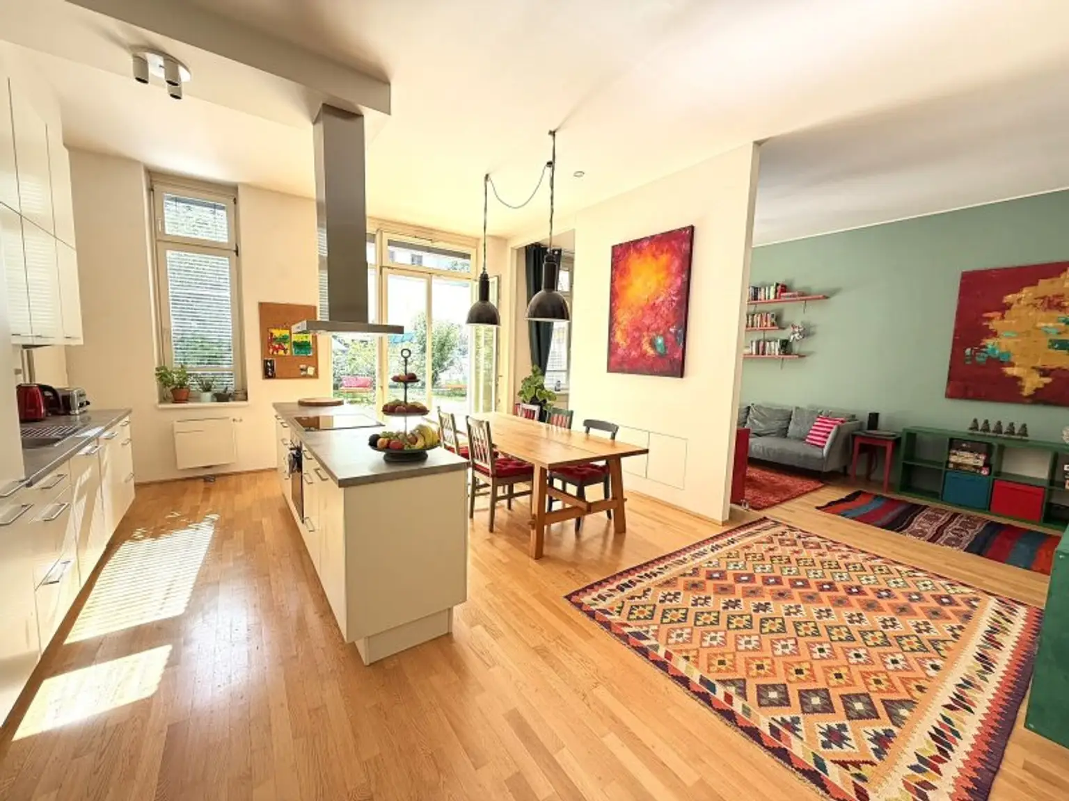 Wohnraum mit Küche und Esstisch und Blick ins Wohnzimmer