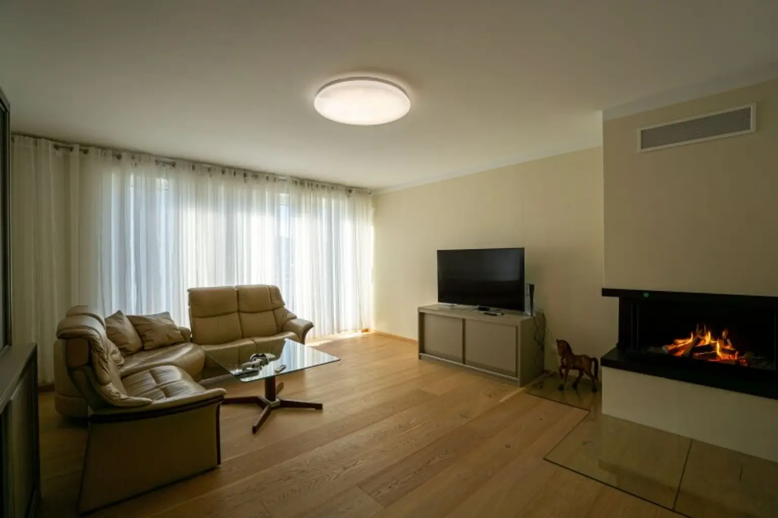 Wohnzimmer mit Kaminofen und Balkonausgang (obere Ebene)