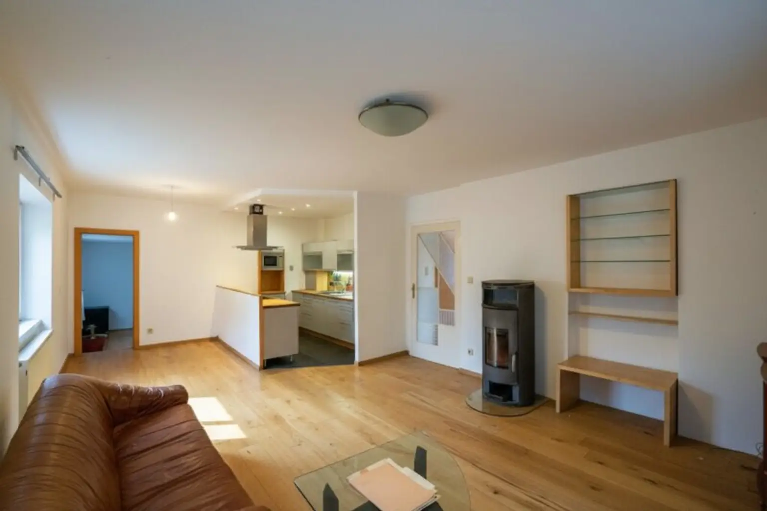 Wohnzimmer mit offener Küche, Schwedenofen und Ausgang auf die Terrasse