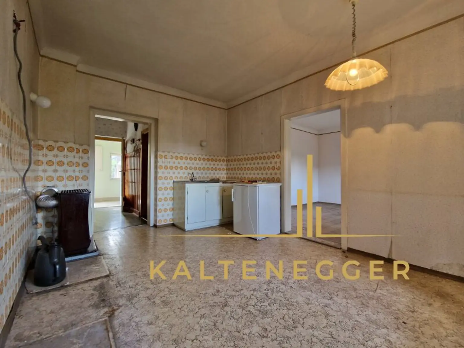 ehemalige Küche mit Zugang zu einem Zimmer und dem Raum mit Kachelofen