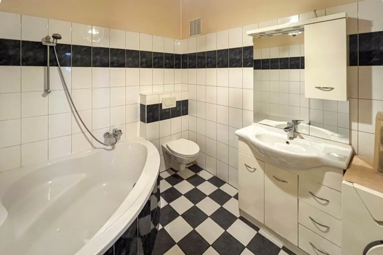 Badezimmer mit Wanne, WC und Waschmaschinenanschluss