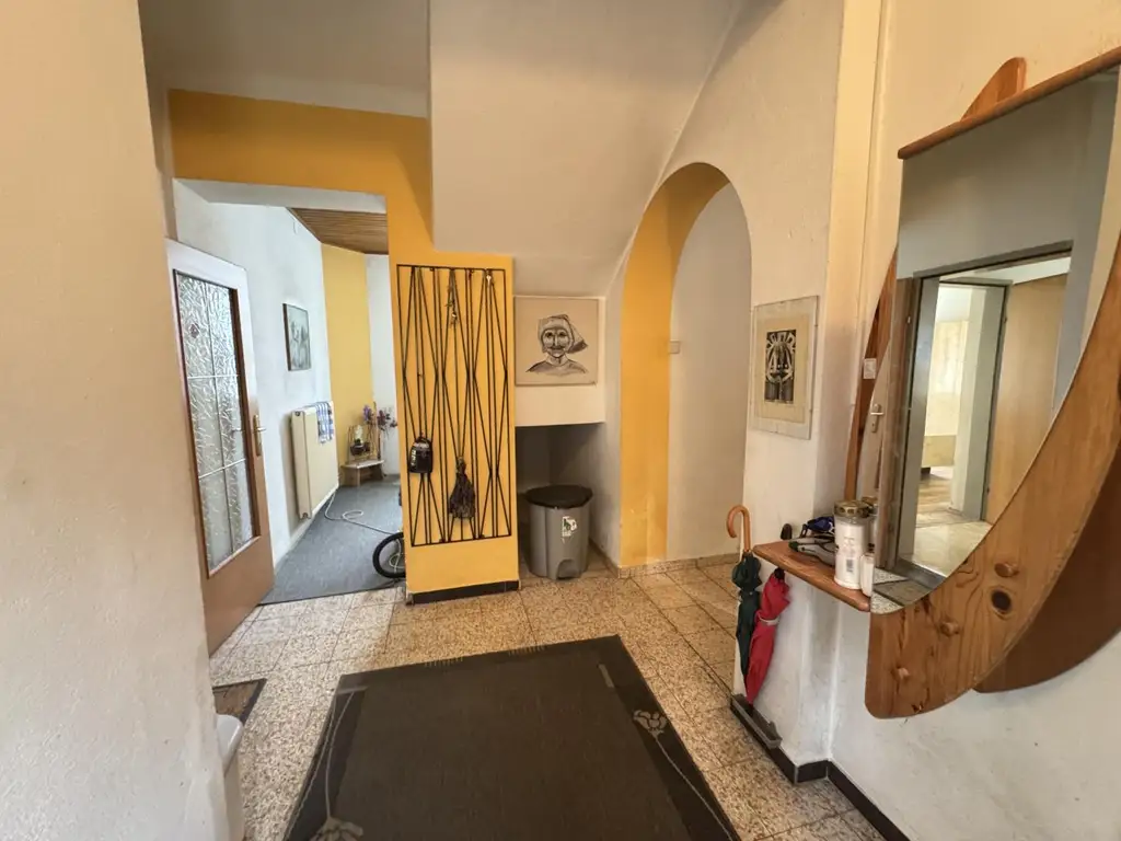 Sanierungsbedürftiges Mehrfamilienhaus mit großem Grundstück und hoher Bebauungsdichte