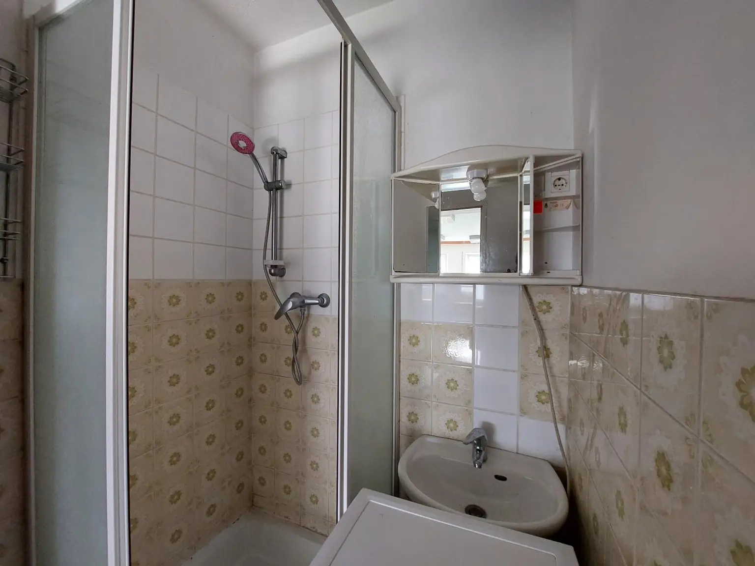 Badezimmer mit Dusche und Handwaschbecken