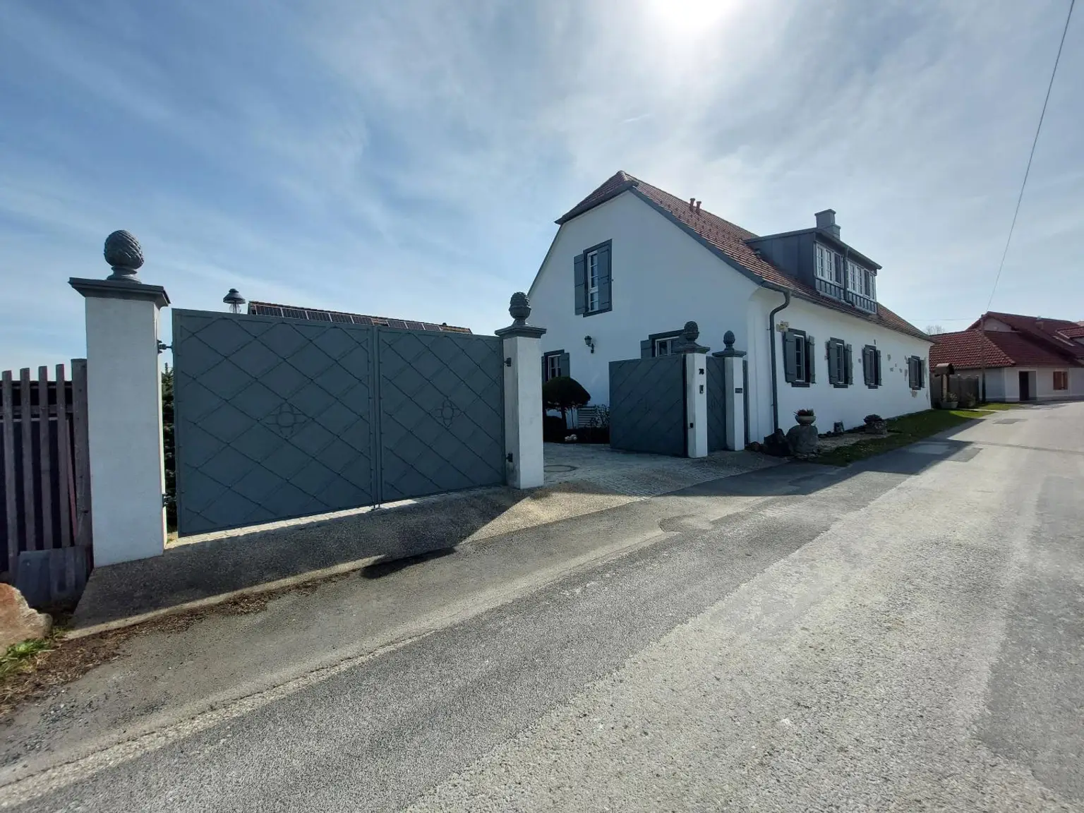 straßenseitige Hausansicht mit Einfahrtstor