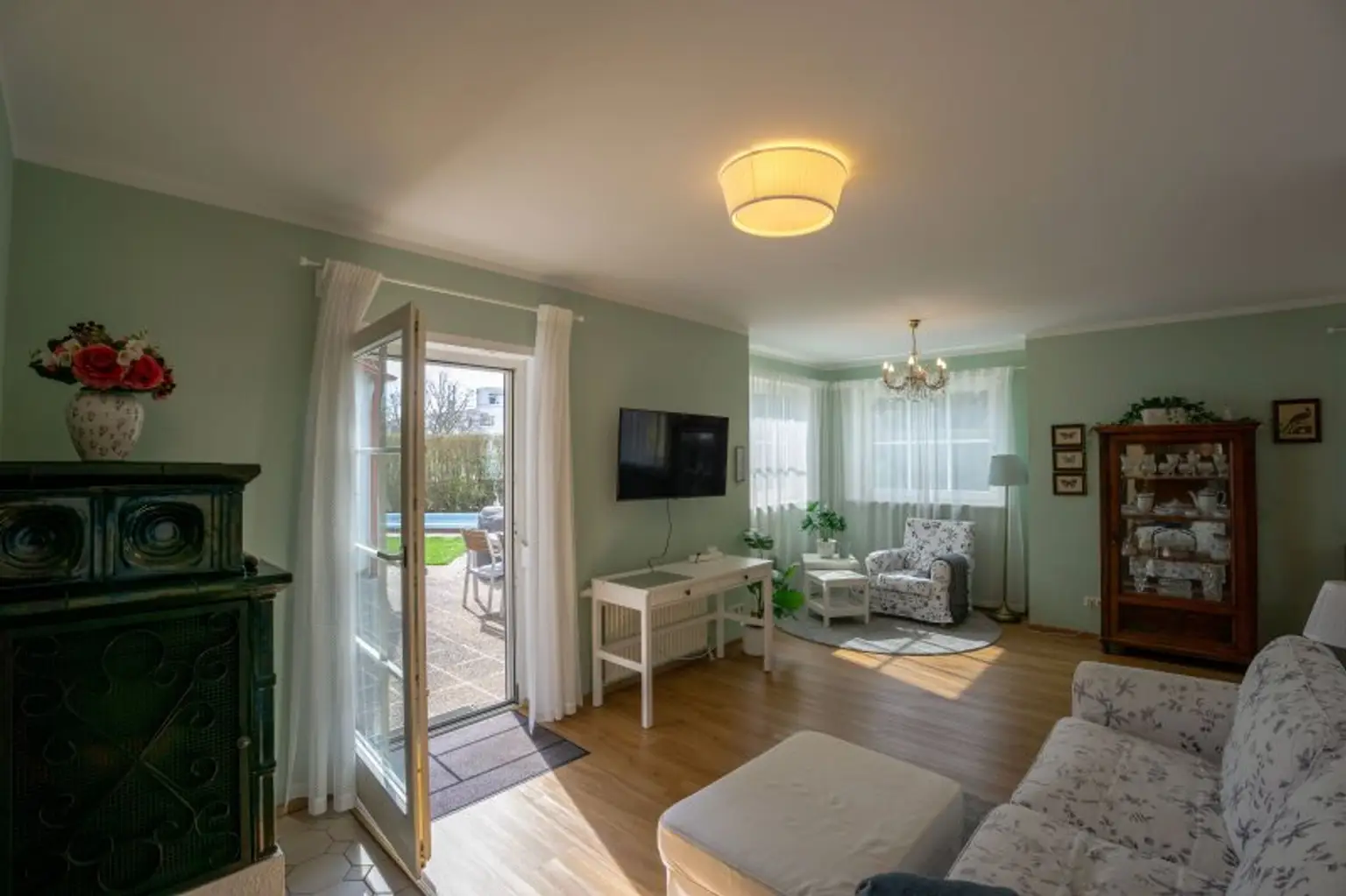 Wohnbereich mit Terrassenausgang, Kachelofen und Verbindungstür zu Wohnung 2