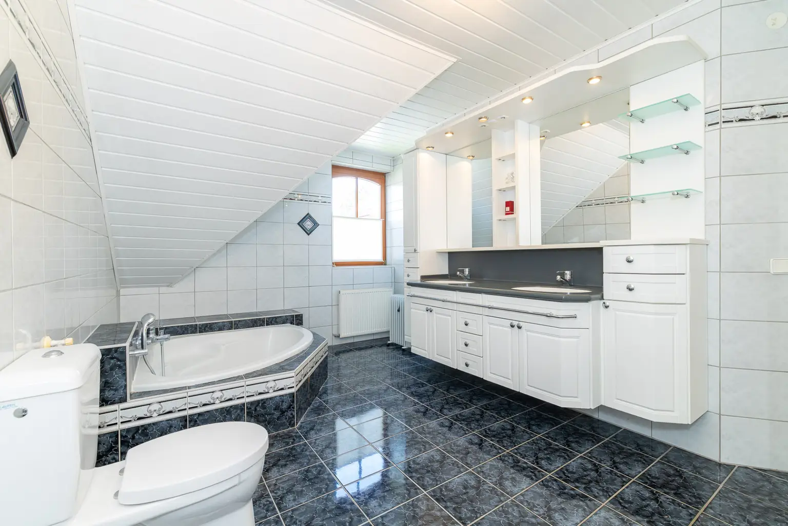 sonnendurchflutetes Badezimmer mit Eckbadewanne und Dusche