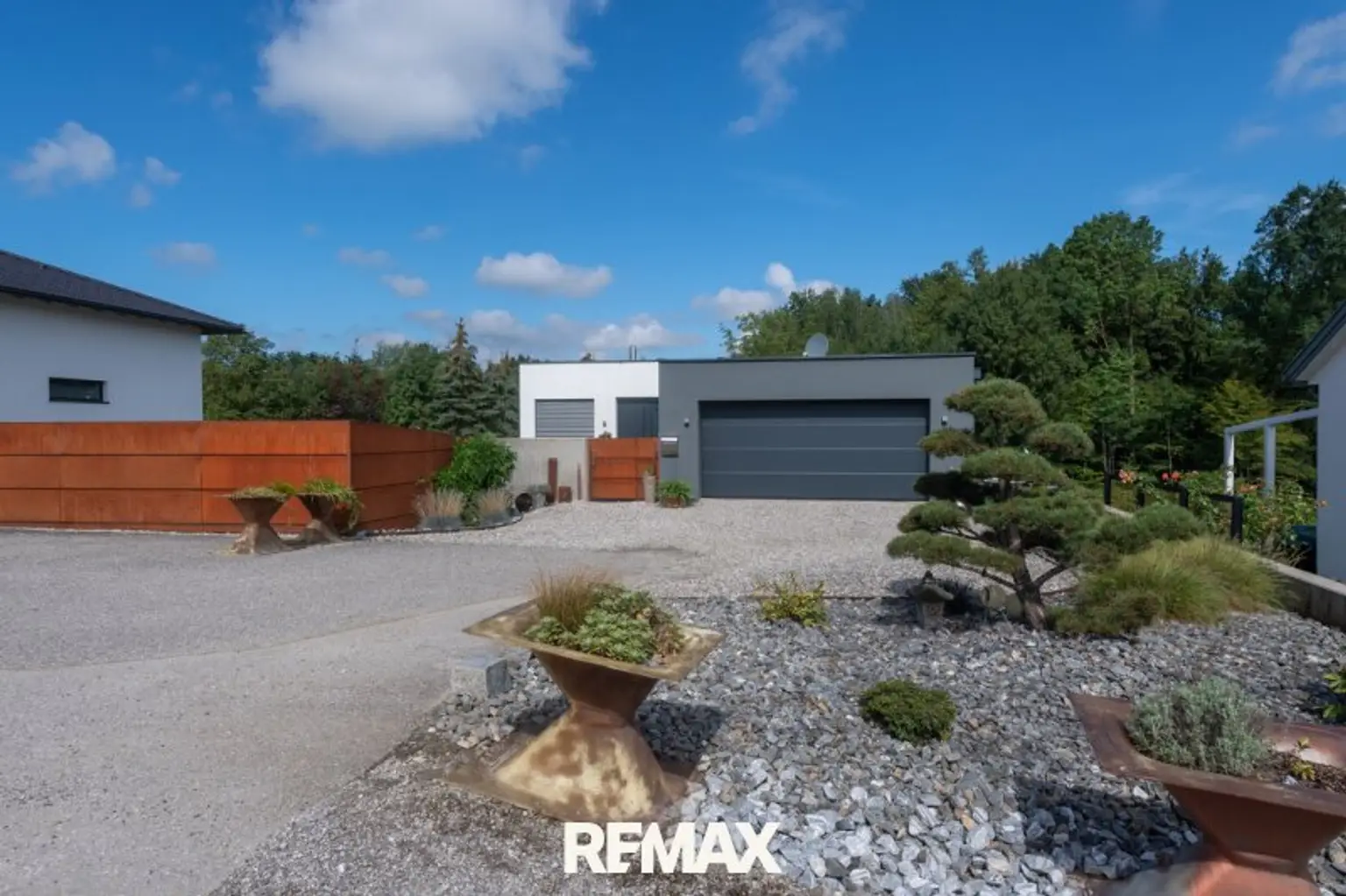 Außenansicht mit Blick zur Garage und den Parkplätzen