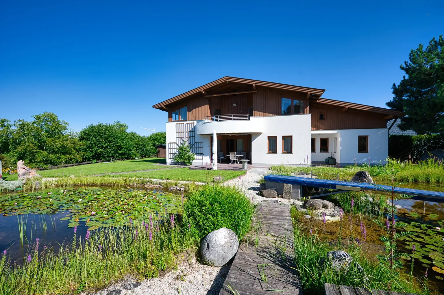 Exklusivität und Privatsphäre pur auf 2.610 m2 Grundfläche! Von der Terrasse in den Schwimmteich.
