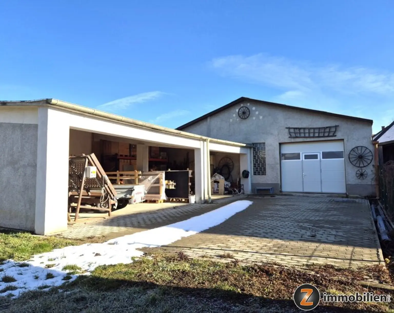 Blick vom Garten zum offenen Lager und der Halle