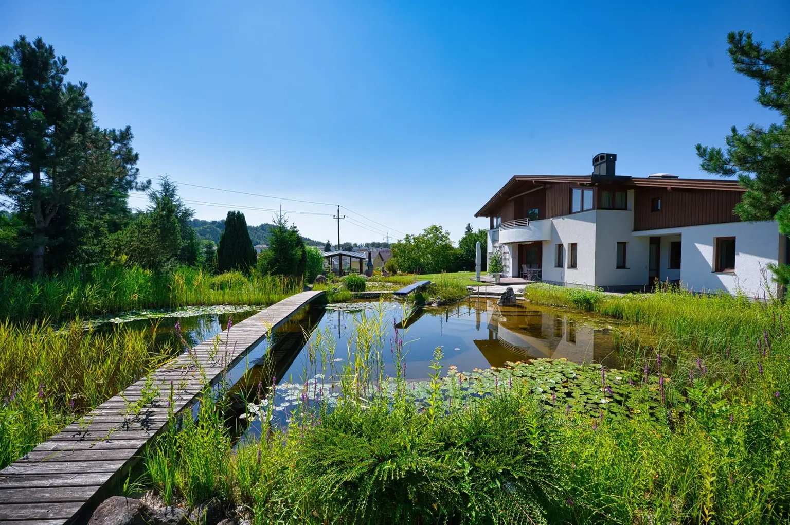 Exklusivität und Privatsphäre pur auf 2.610 m2 Grundfläche! Von der Terrasse in den Schwimmteich.