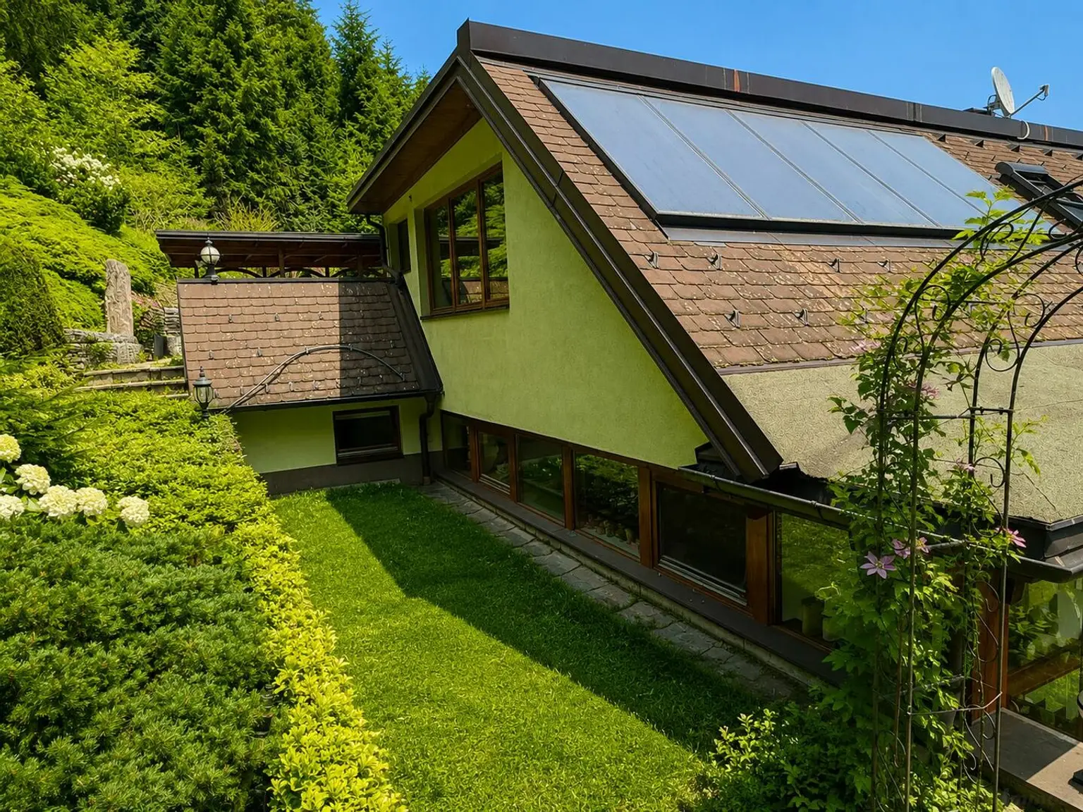 Hausansicht in grüner Gartenlandschaft