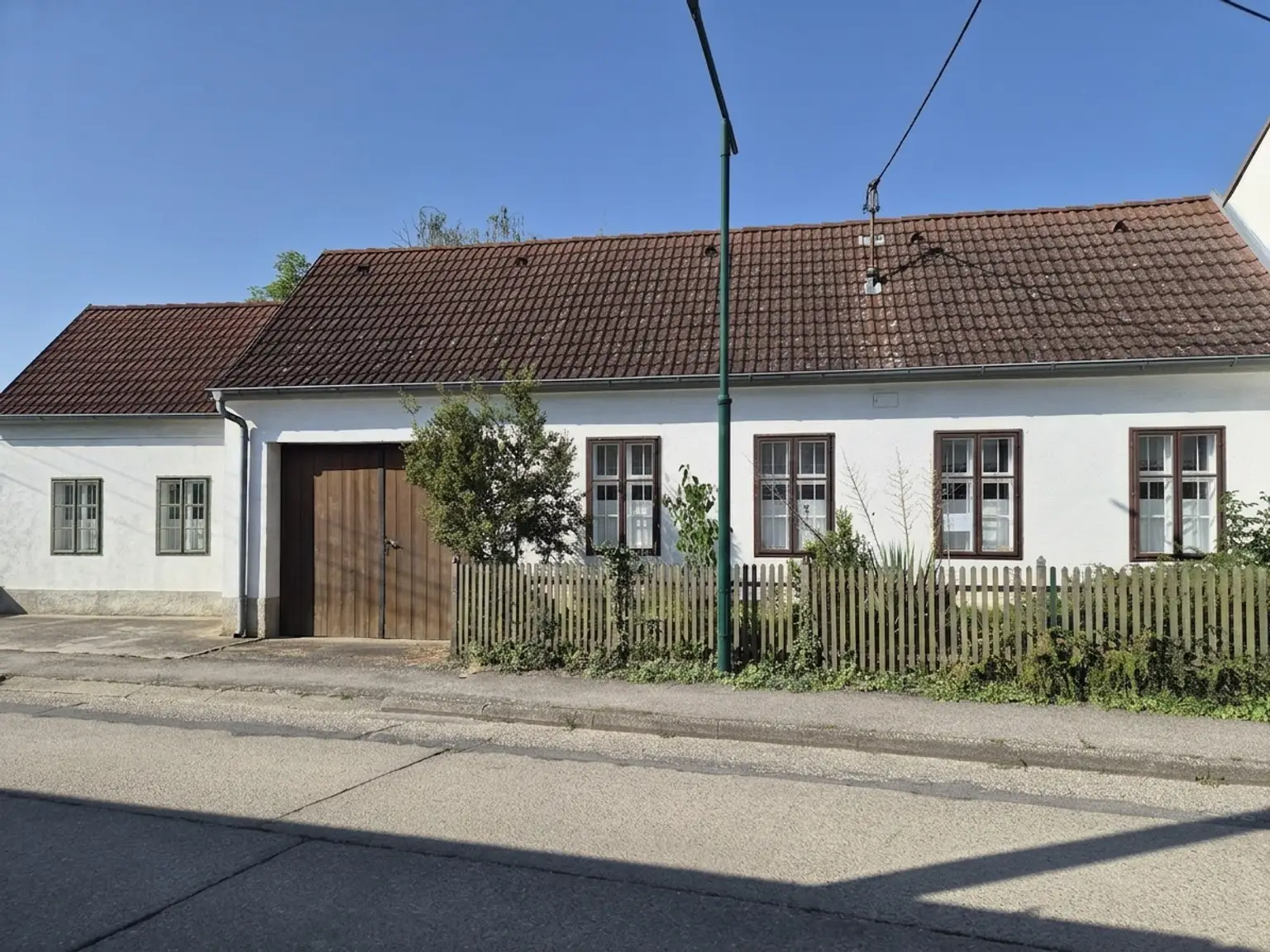 Strassenansicht mit Toreinfahrt und Nebengebäude