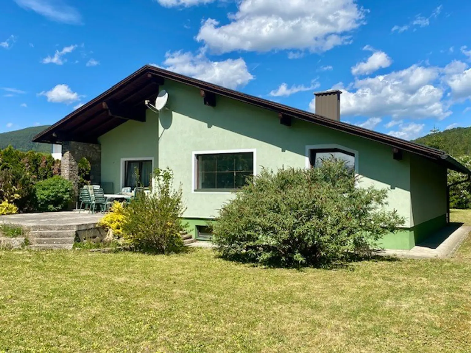 Gartenfront mit Terrasse und ebene Rasenfläche