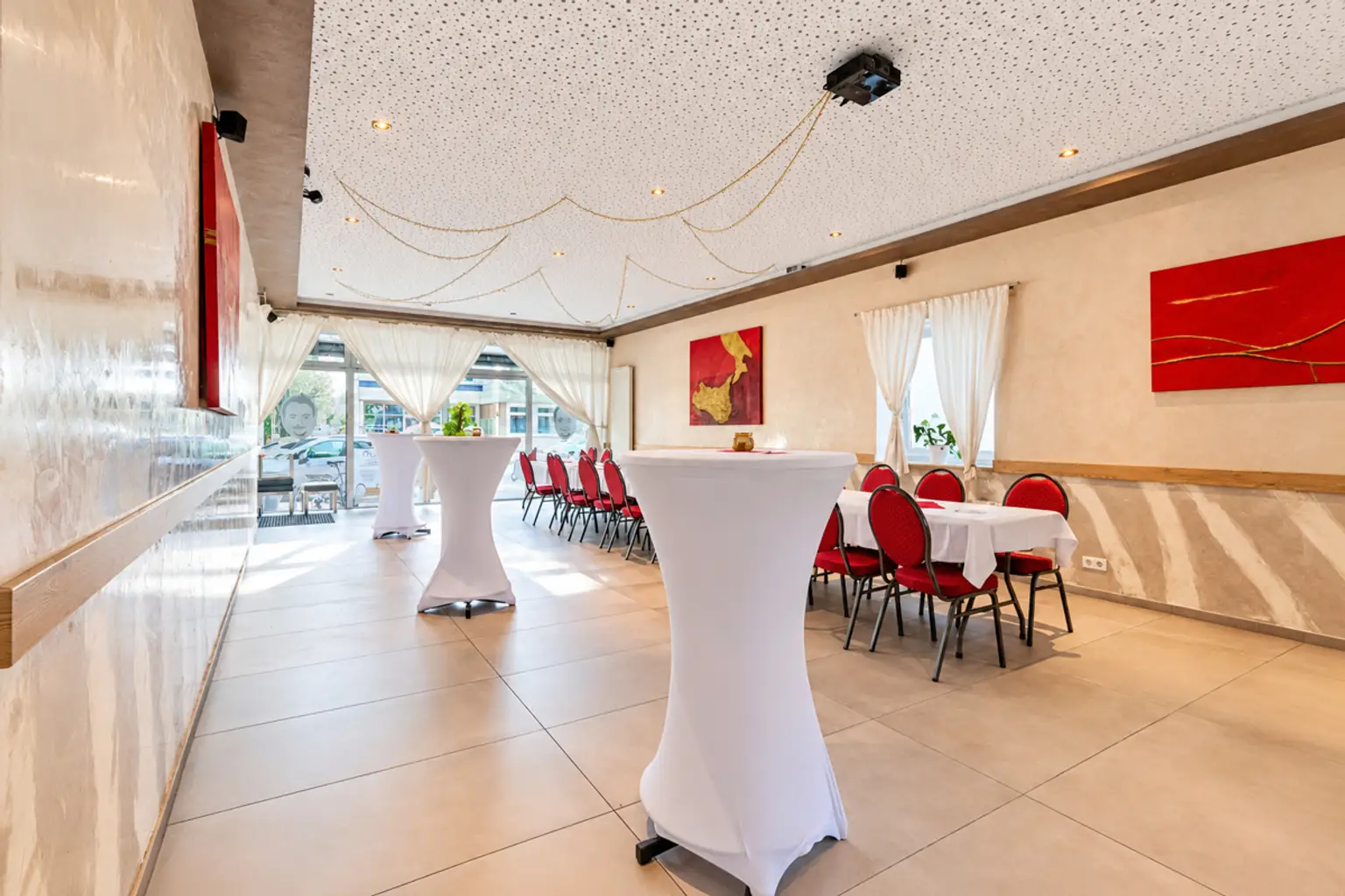 Heller moderner Festsaal mit roten Stühlen