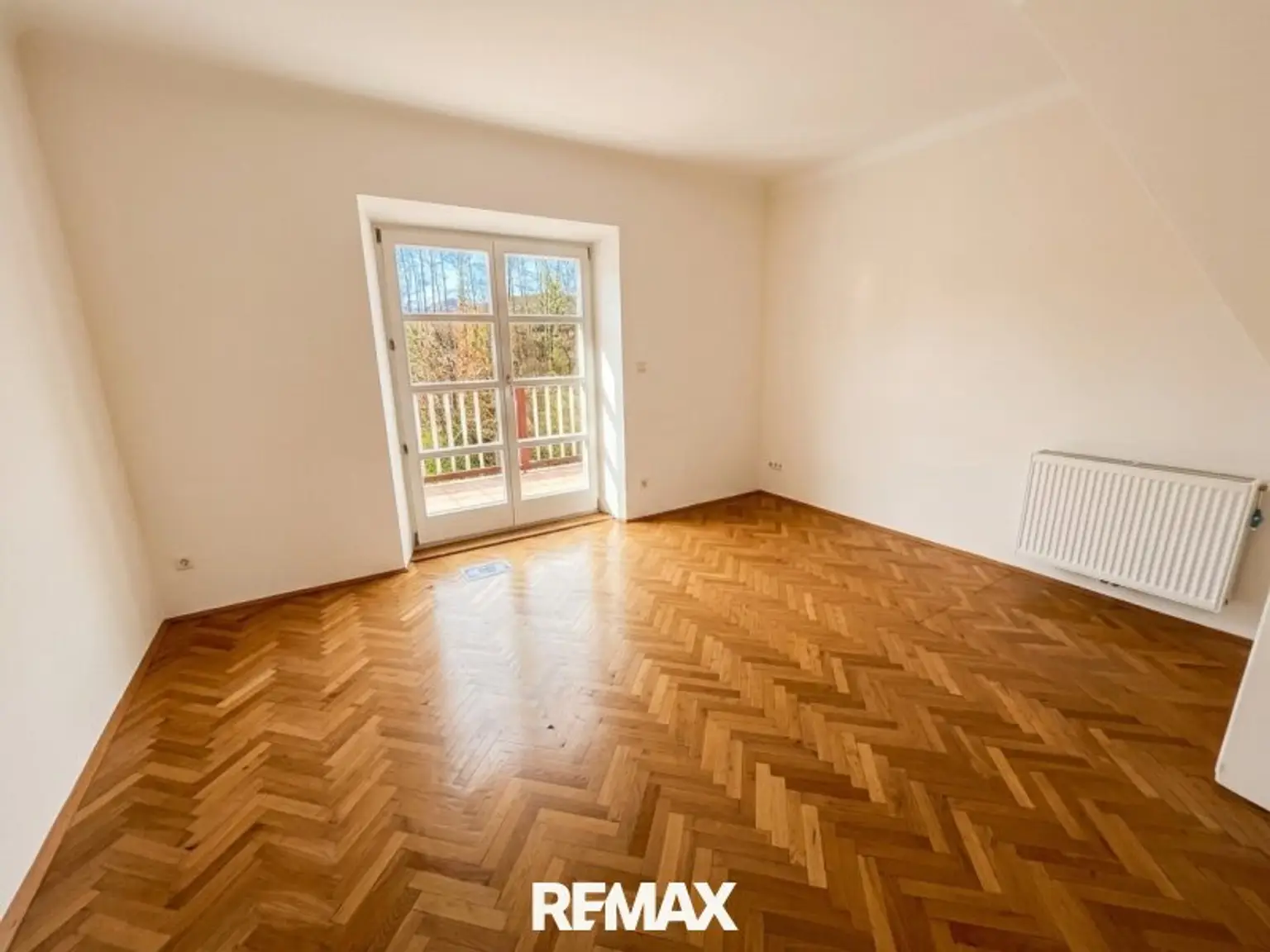 Zimmer im Obergeschoss mit Zugang zum Balkon